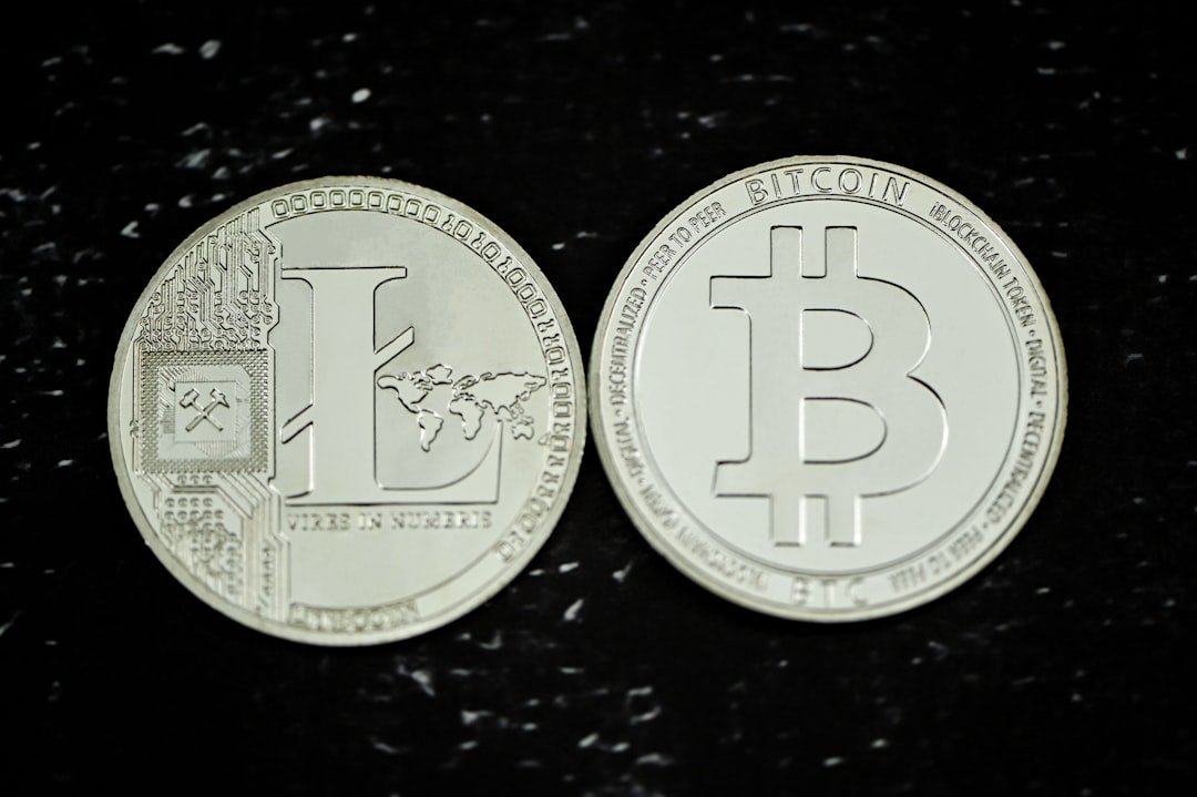 two silver bitcoins sitting on top of a black table