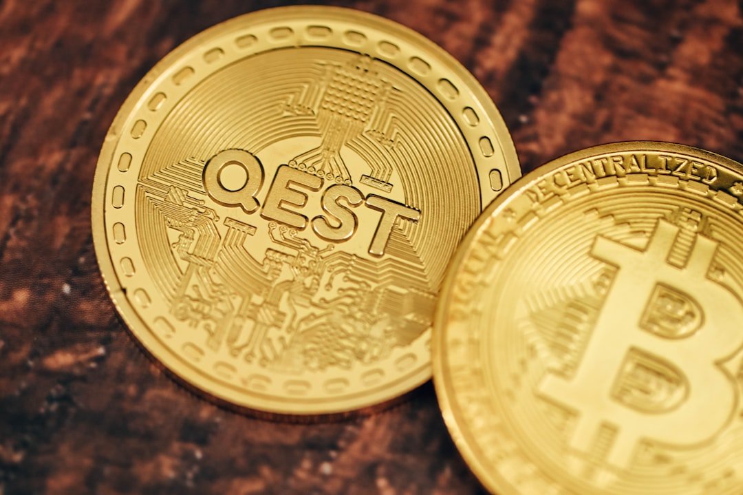 two gold bitcoins sitting on top of a wooden table