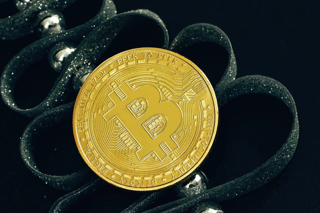 a bit coin sitting on top of a pair of scissors