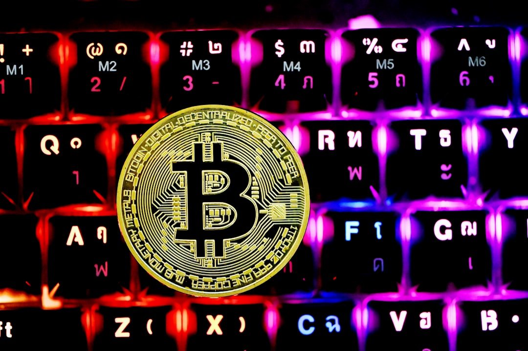 a bitcoin sitting on top of a computer keyboard