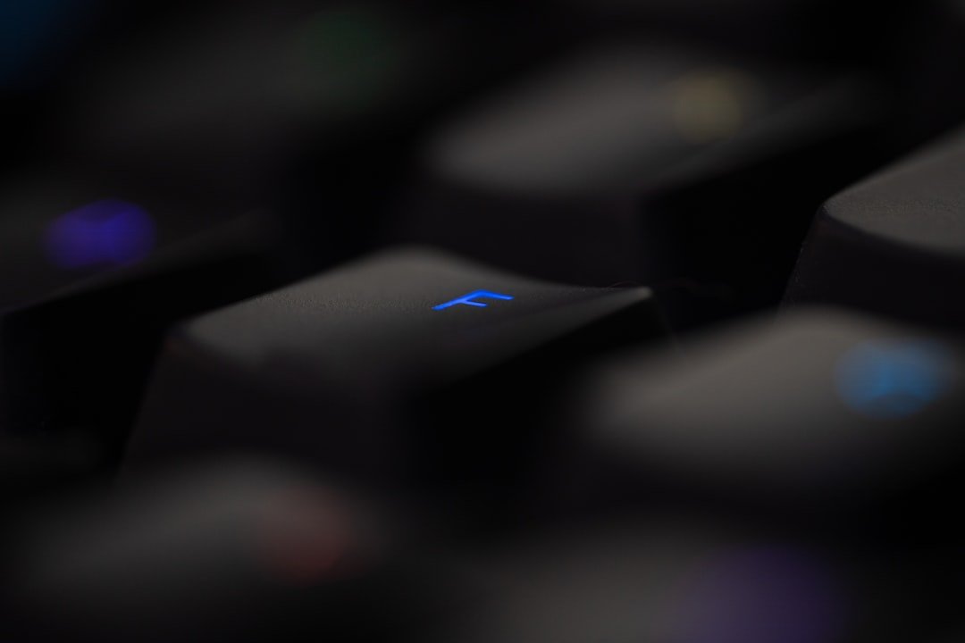 a close up of a black keyboard with a blue light on it